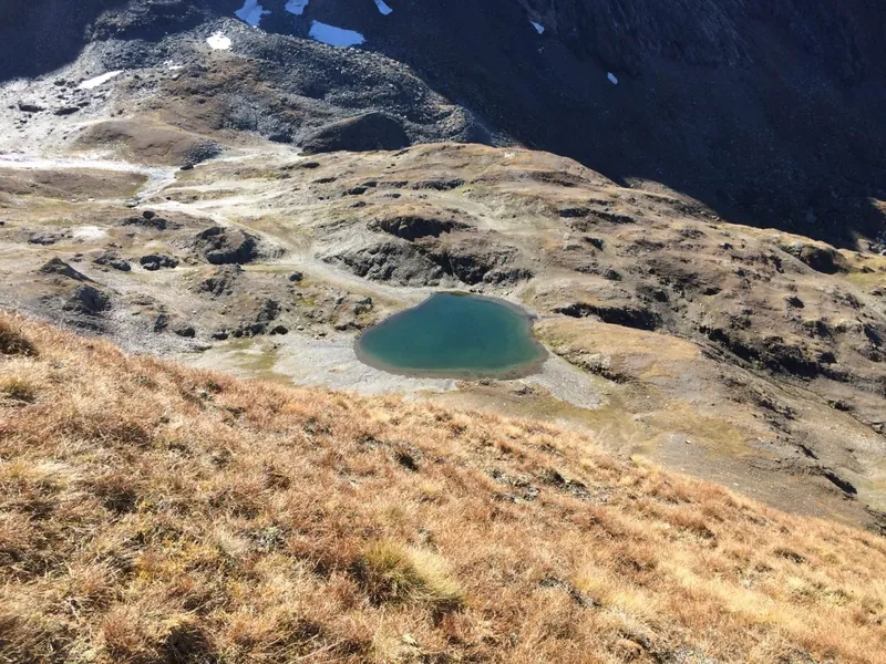 Bergsee zwischen herbstlichen Hängen