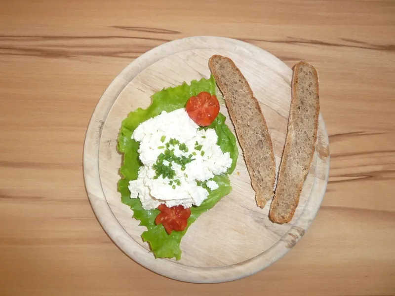 Ziegenfrischkäse mit Brot auf einem Holzbrett