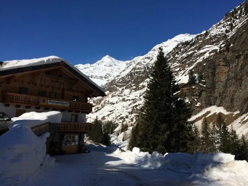 Der Hof im Winter mit Sonne und verschneiten Gipfeln