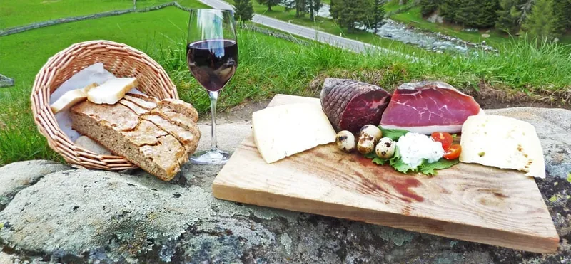 Brettljause mit Wein auf der Wiese
