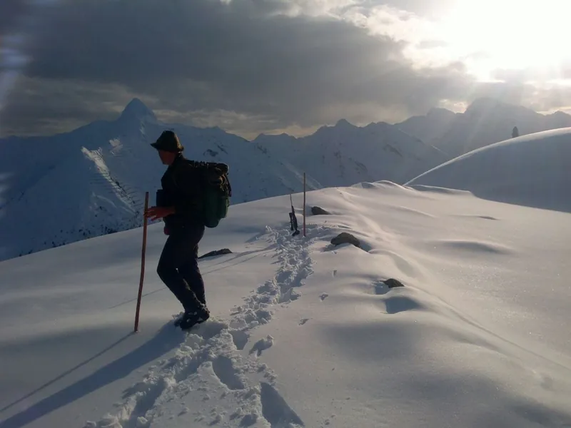 Skitourengeher im Tiefschnee vor den Bergen